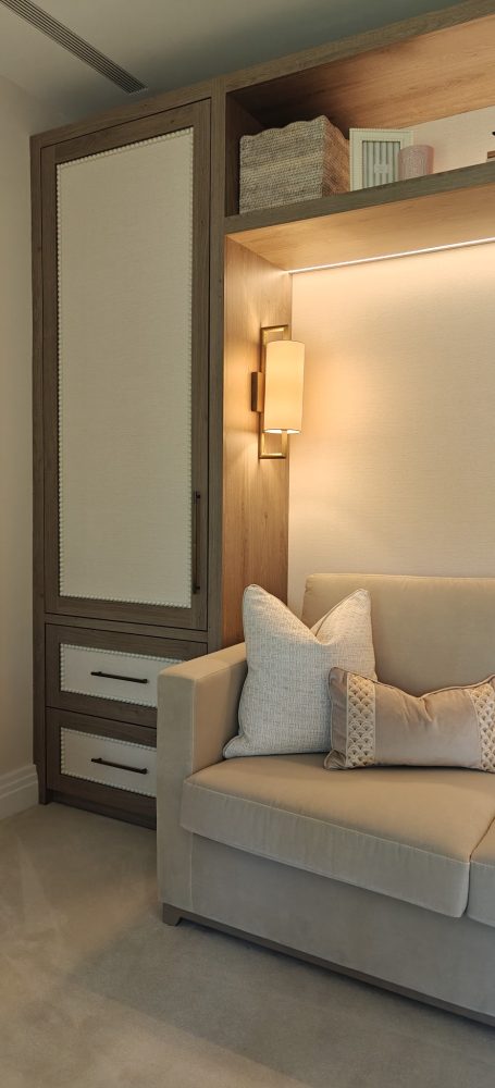 Brown orleans oak finish with wallpapered panels and bobble beading detail. Cozy corner with a light-coloured sofa and a wooden storage unit with soft lighting.
