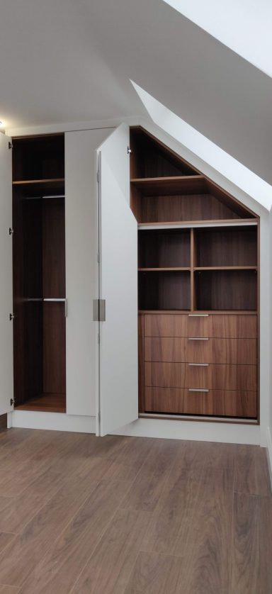 Alpine Matt White corner wardrobe with walnut interior. Modern wood storage units with shelves and drawers in a well-lit room.
