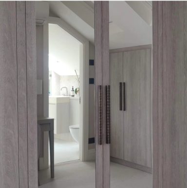 A modern bathroom with wooden cabinetry and visible fixtures in soft lighting.