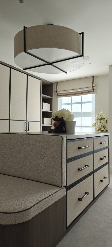 Grey Vicenza Oak dressing room island with drawers Modern interior featuring a stylish light fixture and beige storage units.
