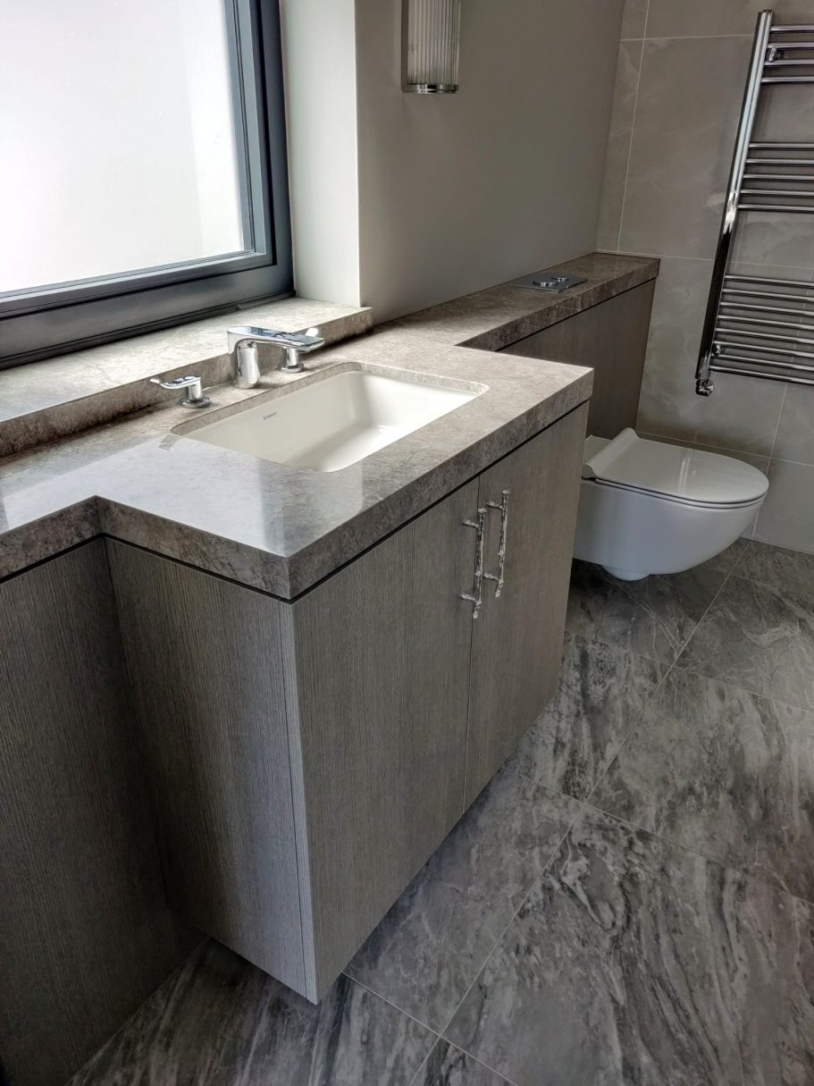 Matrix Rovere vanity cabinet Modern bathroom with a wooden vanity, sink, and a wall-mounted toilet.