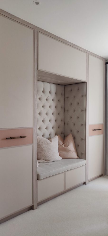 Tivoli wardrobe with reading nook Modern bedroom nook with cushions, patterned wall, and stylish cabinetry.