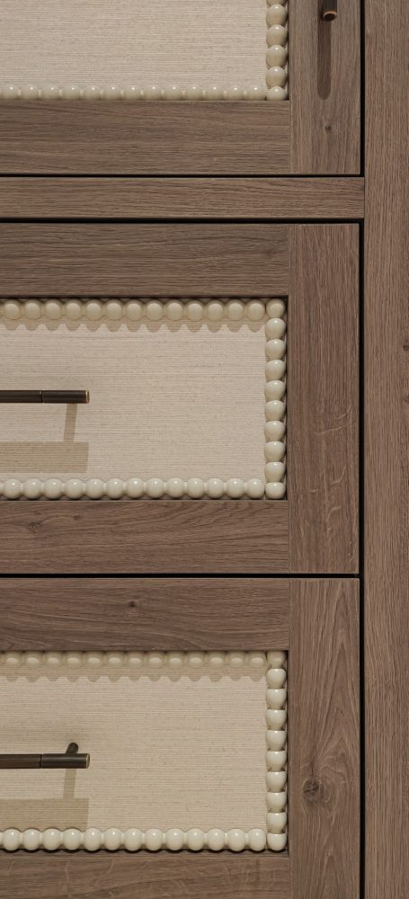 Brown orleans oak finish with wallpapered panels and bobble beading detail. Close-up of wooden cabinet drawers