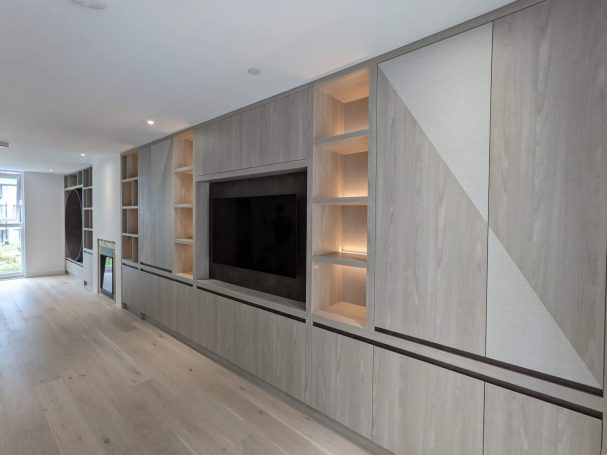 Tivoli and bronze media unit, open shelving with LED's Modern living room with a grey wood feature wall and integrated shelving around a TV.