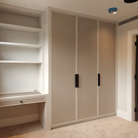 White Grey wardrobe and desk A modern, minimalistic room featuring built-in wardrobes and a desk area.