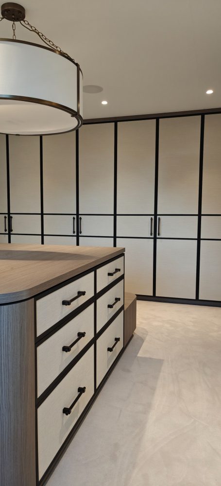 Grey Vicenza Oak dressing room doors with wallpapered panels Modern room with built-in cabinetry and a pendant light fixture.
