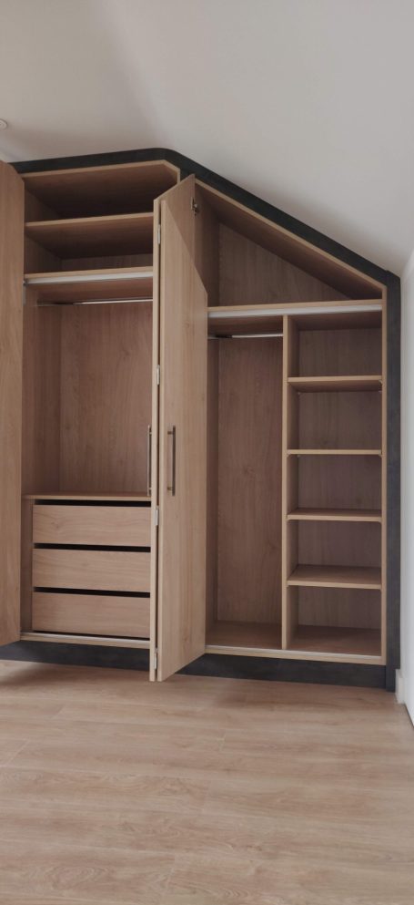 Natural Kendal Oak fitted wardrobe interior Stylish corner wardrobe with shelves and drawers, featuring an open door.