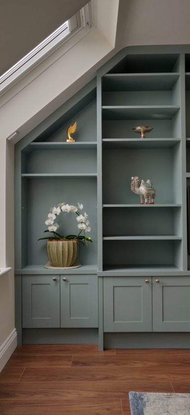 Fjord Green open shelving Light green bookshelf with open shelves and a potted orchid on a wooden floor.
