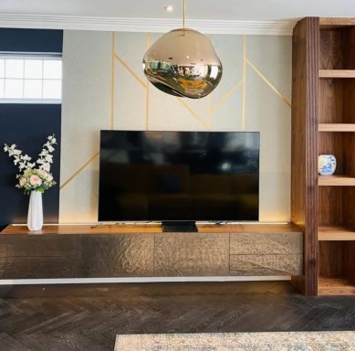 Cracked bronze low sideboard with tall walnut shelving Modern living room featuring a TV on a stylish cabinet, pendant light, and decorative vase.