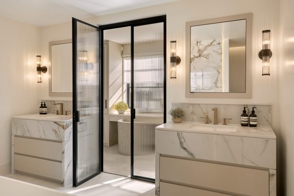 Cashmere Grey two drawer vanities with framed mirrored wall cabinets Modern bathroom with marble vanity units, large mirrors, and stylish lighting.